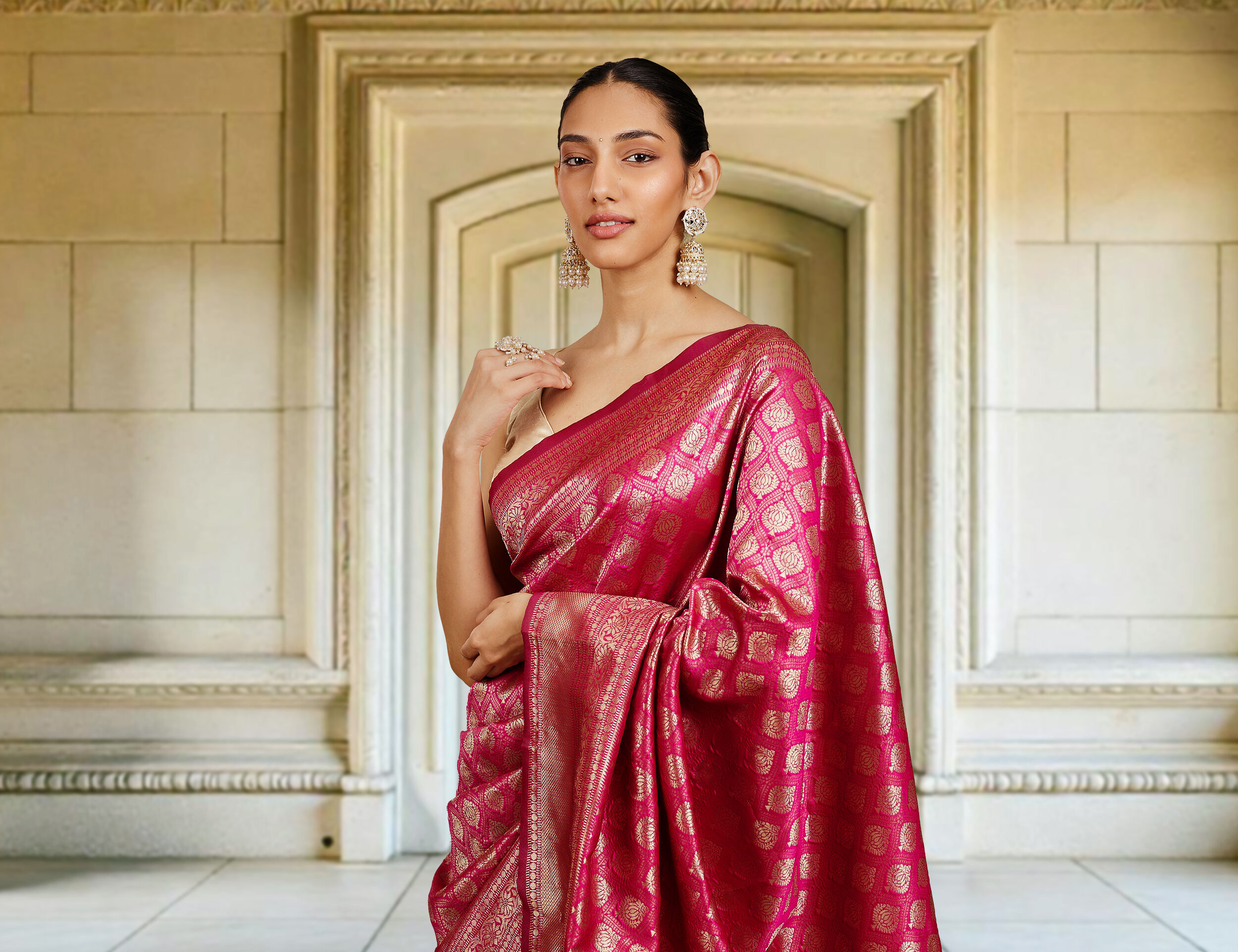 Elegant woman wearing a traditional red zari saree, paired with stylish earrings for a timeless look.